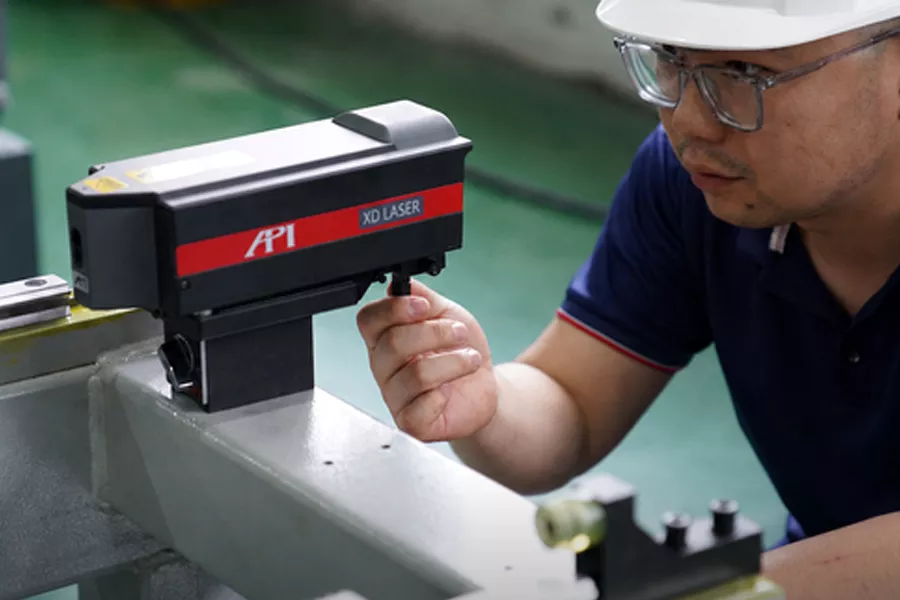 Technician checking machine geometry with a laser measuring instrument