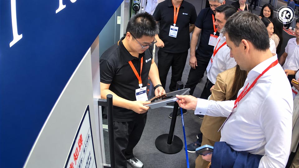 Booth Consultation At Ciif 2026 Qingyun representatives discuss laser-cutting equipment with an international visitor at CIIF 2026